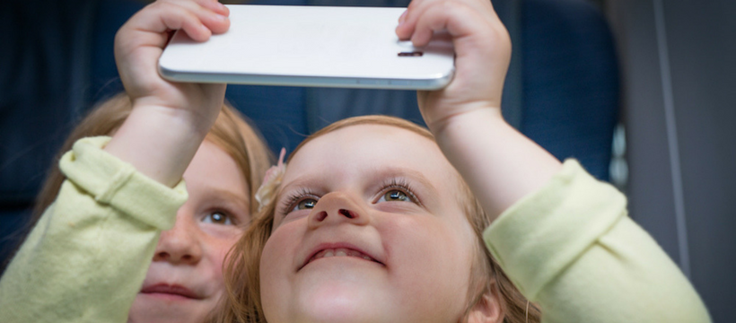 deux enfants regardent un smartphone dans l'eurostar odyssey