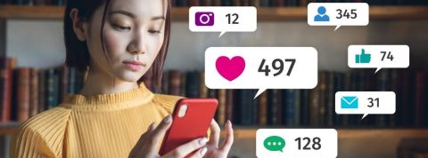 Quelle place accorder aux réseaux sociaux ? Une jeune femme regardant les notifications sur son téléphone