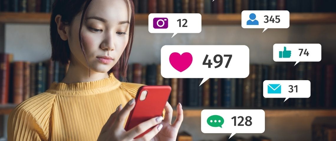 Quelle place accorder aux réseaux sociaux ? Une jeune femme regardant les notifications sur son téléphone