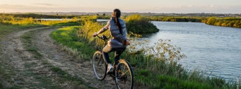 Fermes-D'Avenir Jeune femme à vélo sur une route de campagne