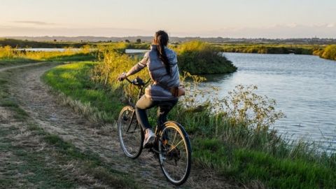 Jeune femme à vélo sur une route de campagne