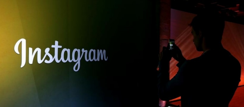 un homme filme le logo instagram