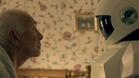 Un vieil homme et un robot se regardent