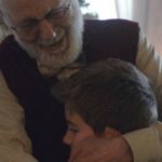 Un grand-père prenant son petit-fils dans ses bras pour SOS Amitié