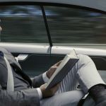 un homme lit dans une voiture autonome
