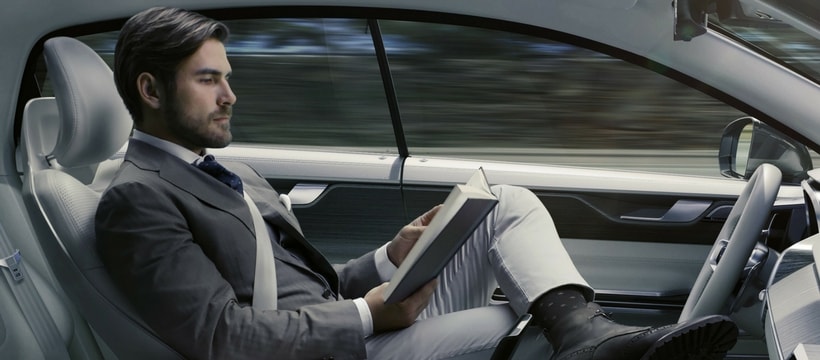 voiture-autonome un homme lit dans une voiture autonome