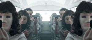 gens assis dans un bus aveec leur smartphone et des masques