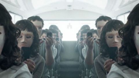 gens assis dans un bus aveec leur smartphone et des masques