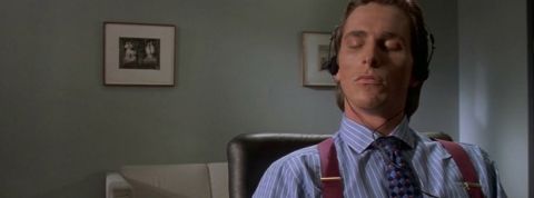 christian bale assis a son bureau dans american psycho
