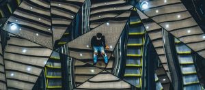 un homme assis sur des escaliers, se reflétant dans plusieurs miroirs