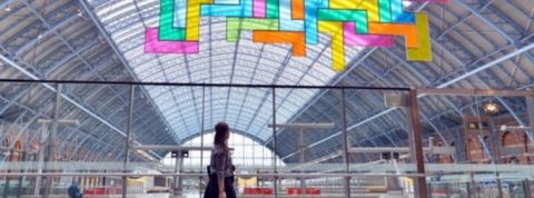 tetris Une femme marchant devant une sculpture de Tetris