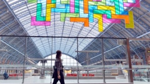 tetris Une femme marchant devant une sculpture de Tetris