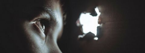 voyeur oeil enfant Un oeil d'enfant qui regarde dans le trou d'un mur