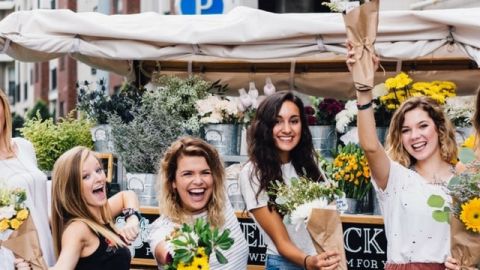 Des femmes heureuses agitent des fleurs