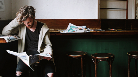 Homme déprimé qui lit un journal