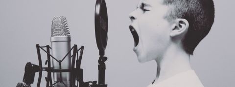 Un petit garcon qui crie dans un micro