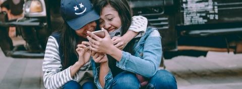 smartphone amis deux amies rient ensemble devant leur smartphone