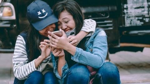 smartphone amis deux amies rient ensemble devant leur smartphone