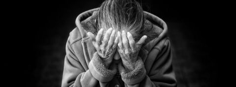 une femme se tient la tete entre ses mains