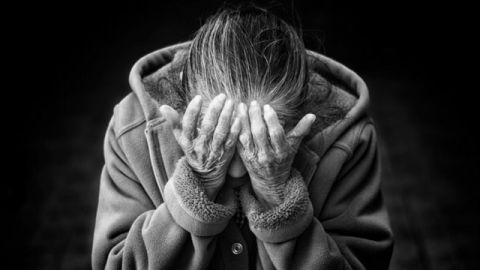 une femme se tient la tete entre ses mains