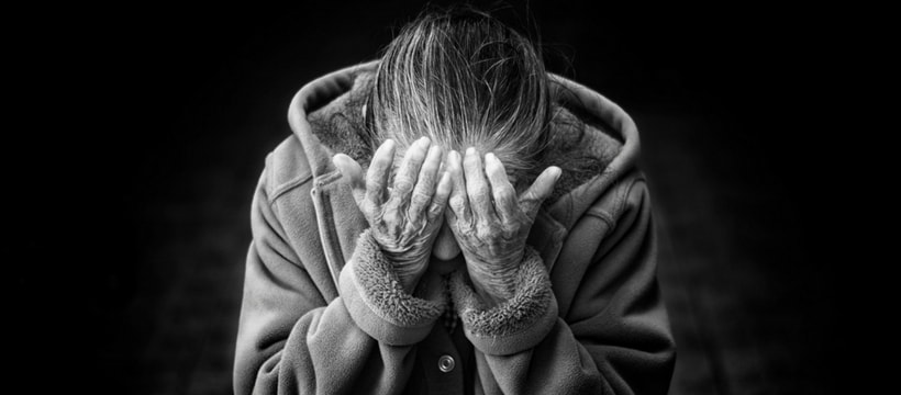 une femme se tient la tete entre ses mains