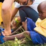 Un enfant noir en train d'essayer une chaussure