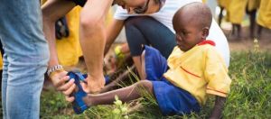 Un enfant noir en train d'essayer une chaussure