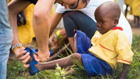 Un enfant noir en train d'essayer une chaussure