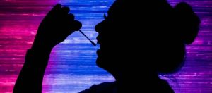 une femme en train de prélever son ADN avec un coton tige