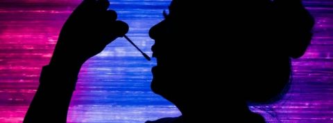 une femme en train de prélever son ADN avec un coton tige