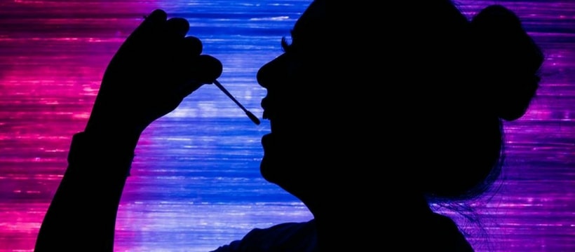 cotontige une femme en train de prélever son ADN avec un coton tige