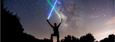 space Un homme en train de brandir des lasers sur un ciel étoilé