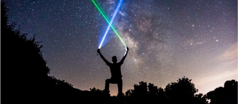 space Un homme en train de brandir des lasers sur un ciel étoilé