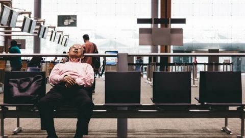 une personne dort en attendant son vol