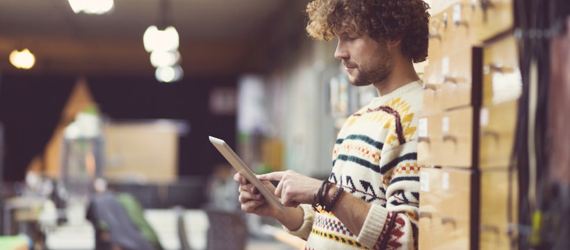 Amazon Un homme au milieu de cartons en train d'utiliser une tablette
