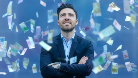 homme en costume avec des billets qui volent