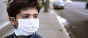 enfant avec un masque respiratoire dans la rue
