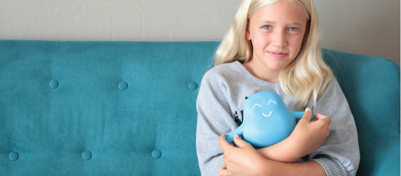 meyko petite fille blonde assise sur un canapé bleu