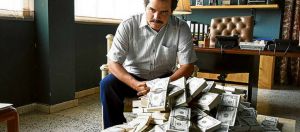 Une scène de Narcos, où Pablo Escobar est assis devant une pile de billets