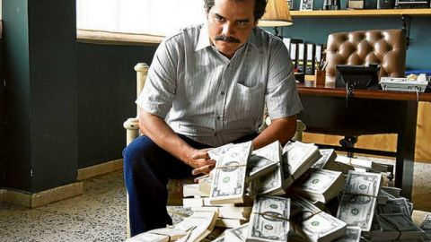 Une scène de Narcos, où Pablo Escobar est assis devant une pile de billets