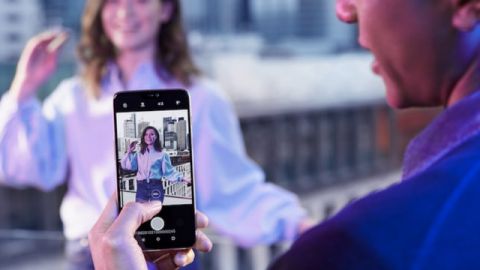 Un homme en train de prendre une femme en photo avec le OnePlus 6