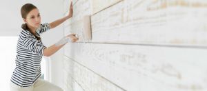 une femme qui peint une maison