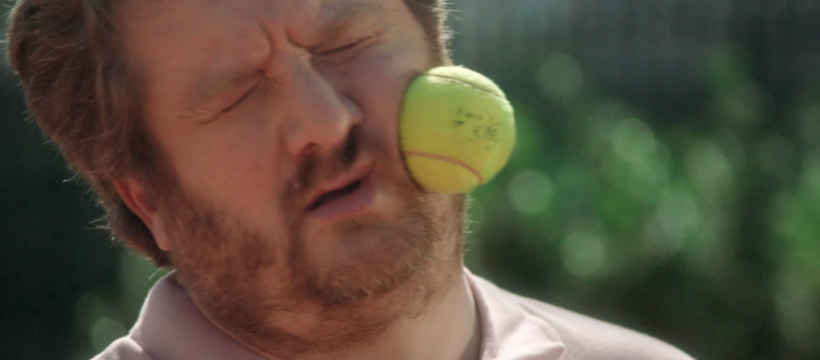 rg homme qui reçoit une balle de tennis sur le visage