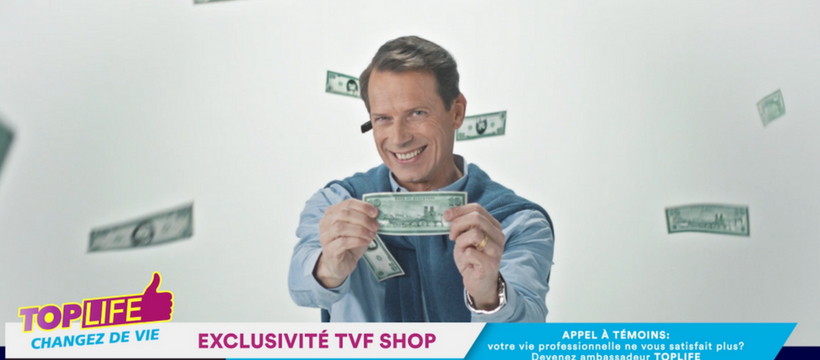 iad un homme qui tient un billet à la télévision