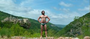 Un homme en slip devant un chateau