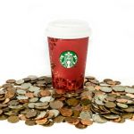 Un gobelet Starbucks posé sur des pièces de monnaie