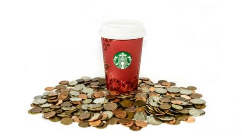 Un gobelet Starbucks posé sur des pièces de monnaie
