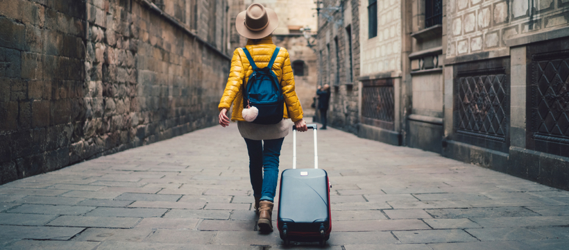week-end une femme de dos qui part en vacances avec sa valise