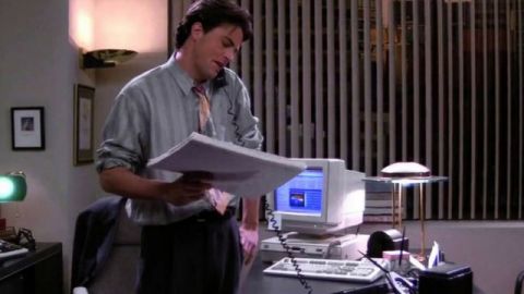 Chandler Bing au téléphone, dans son bureau, dans la série Friends