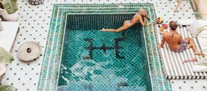 Une femme dans une piscine, et son compagnon, au riad Yasmine à Marrakech